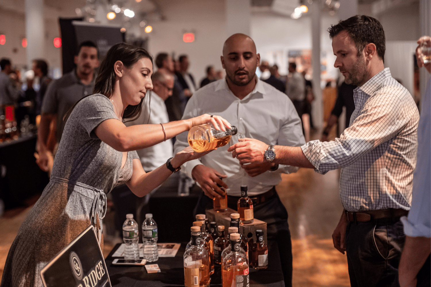 waiter at the stand pouring whiskey at Whiskies of the World