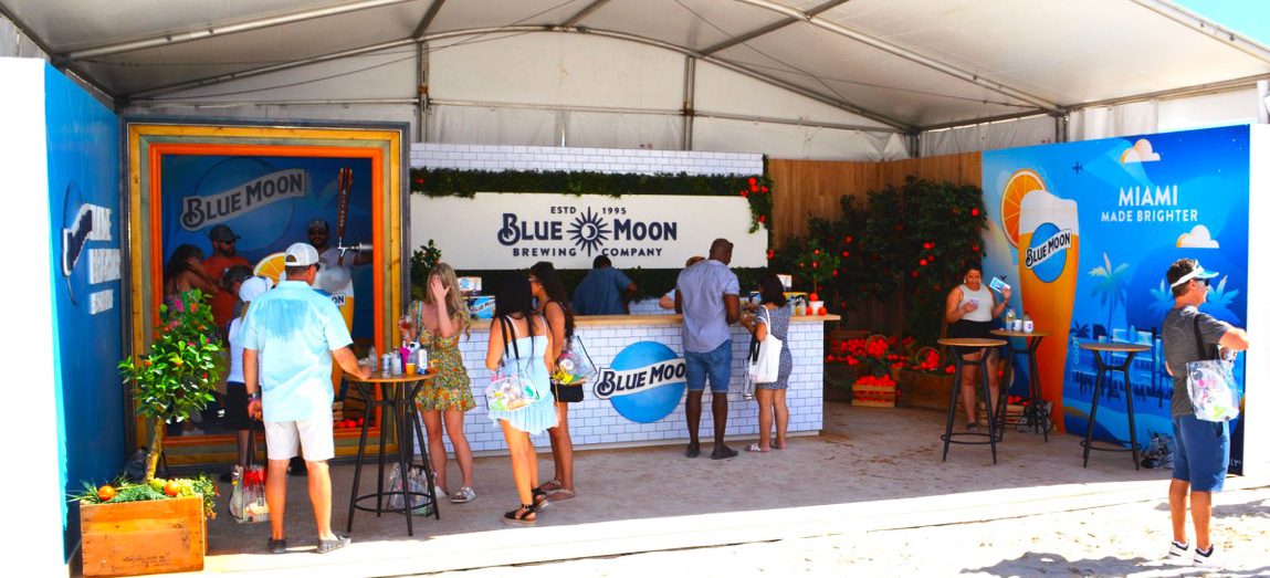 blue moon stand with people drinking